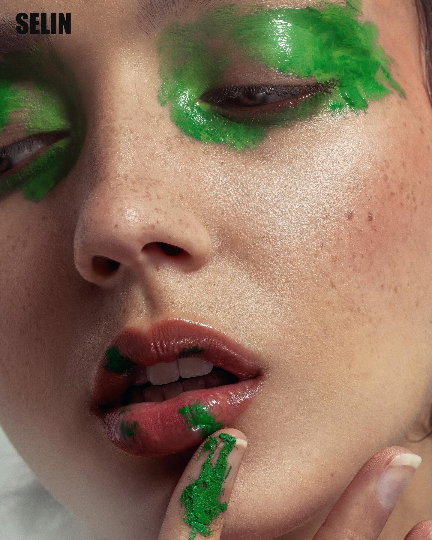 Close beauty portrait with expressive green makeup